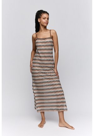 Maxi-jurk met dunne bandjes, met een geometrisch patroon in bruin, wit en terracottakleuren. Lichtgewicht, vloeiende stof tot aan de enkels.