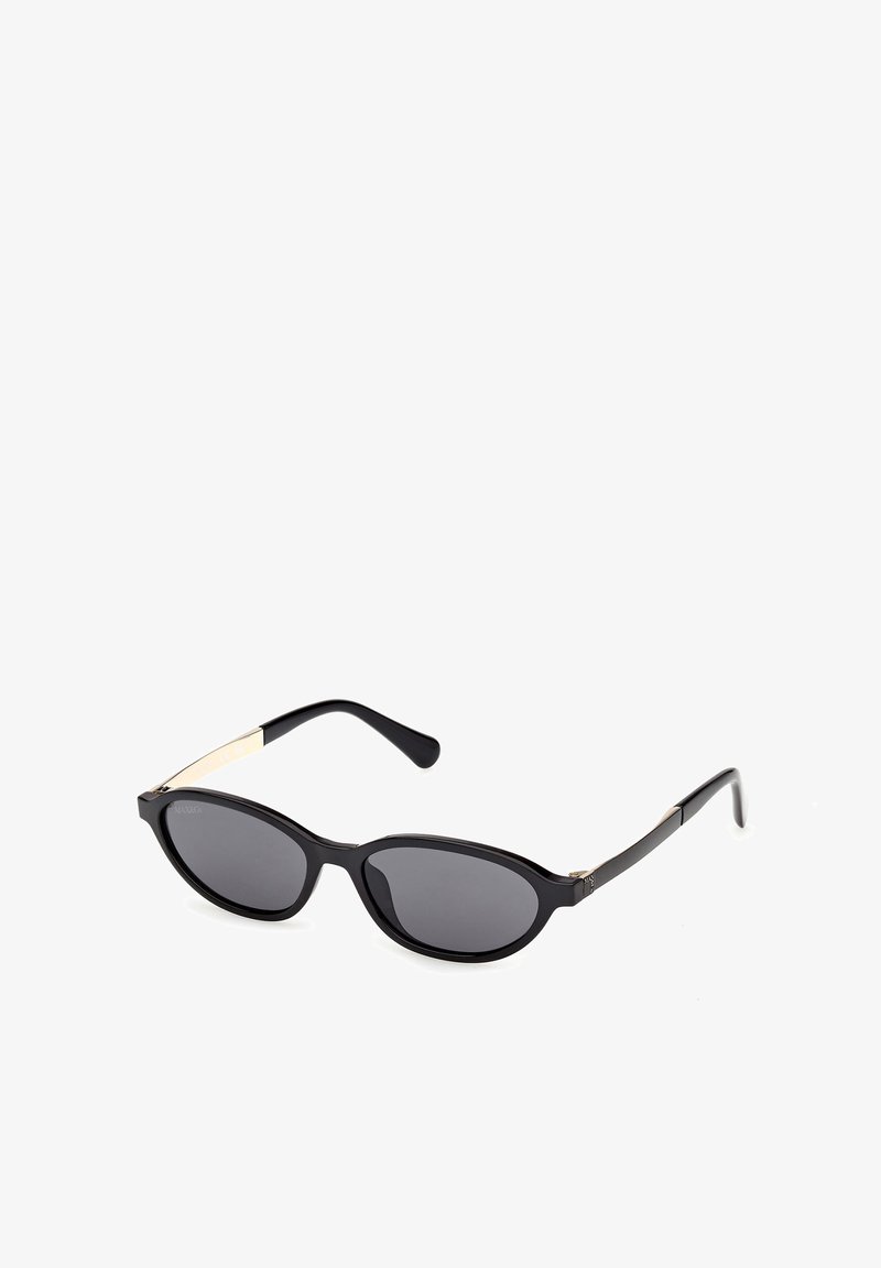 Lunettes de soleil ovales noires avec verres foncés et branches fines ornées d'accents dorés sur fond blanc.