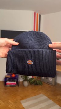 Tengerészkék kötött sapka bordázott mintával és hajtóka mandzsettával. Az elején kisméretű, márkázott logó folttal.