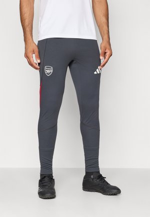 Grå athletic leggings med et tætsiddende design, der har røde detaljer, Arsenal-logo og Adidas-branding på hoften. Fremstillet af strækbart materiale.