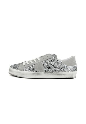 Sneaker bassa con lacci bianchi, dettagli in suede grigio e glitter argentati che coprono la maggior parte della tomaia, con suola bianca leggermente consumata.