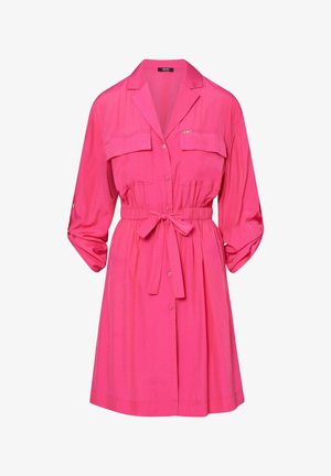 Robe rose vif à manches longues avec col, deux poches poitrines, taille cintrée nouée avec un nœud et manches retroussées.