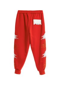 Pantalones de chándal rojos, confeccionados en tela suave, que presentan diseños bordados en blanco y dorado en cada pierna, y una cinturilla elástica con etiqueta de marca.