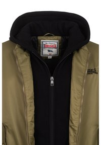 Giacca bomber verde oliva con interno felpato nero. Caratterizzata da chiusura con zip, texture morbida e etichetta con logo. Design a doppio strato.