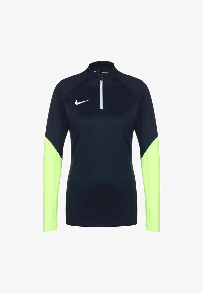 Haut de sport noir à manches longues avec manches inférieures jaune néon, logo Nike blanc sur la poitrine et courte fermeture éclair à l'avant.