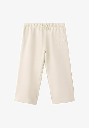 Široke hlače krem barve z elastičnim pasom, vrvico in našitkom v obliki cvetlice na zgornjem desnem stegnu.