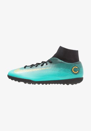 Chaussure de football turquoise et noire avec un swoosh et un logo dorés, équipée de lacets noirs et d'un col cheville noir en forme de chaussette.