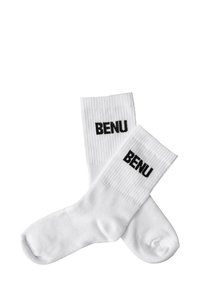 Białe skarpetki sportowe za kostkę z prążkowanymi ściągaczami, na których znajduje się czarny napis "BENU" na każdym ściągaczu, ułożone płasko i częściowo nałożone na siebie na białym tle.