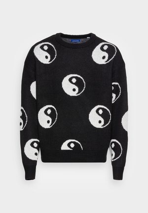 Pull en maille noire avec des symboles yin-yang blancs répartis sur le devant, les manches et les épaules, avec des poignets et un ourlet côtelés.