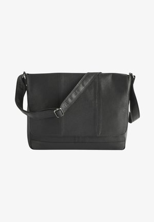 Czarna skórzana torba messenger z teksturowaną klapą, regulowanym paskiem i minimalistycznym designem. Posiada gładkie i chropowate sekcje skóry.