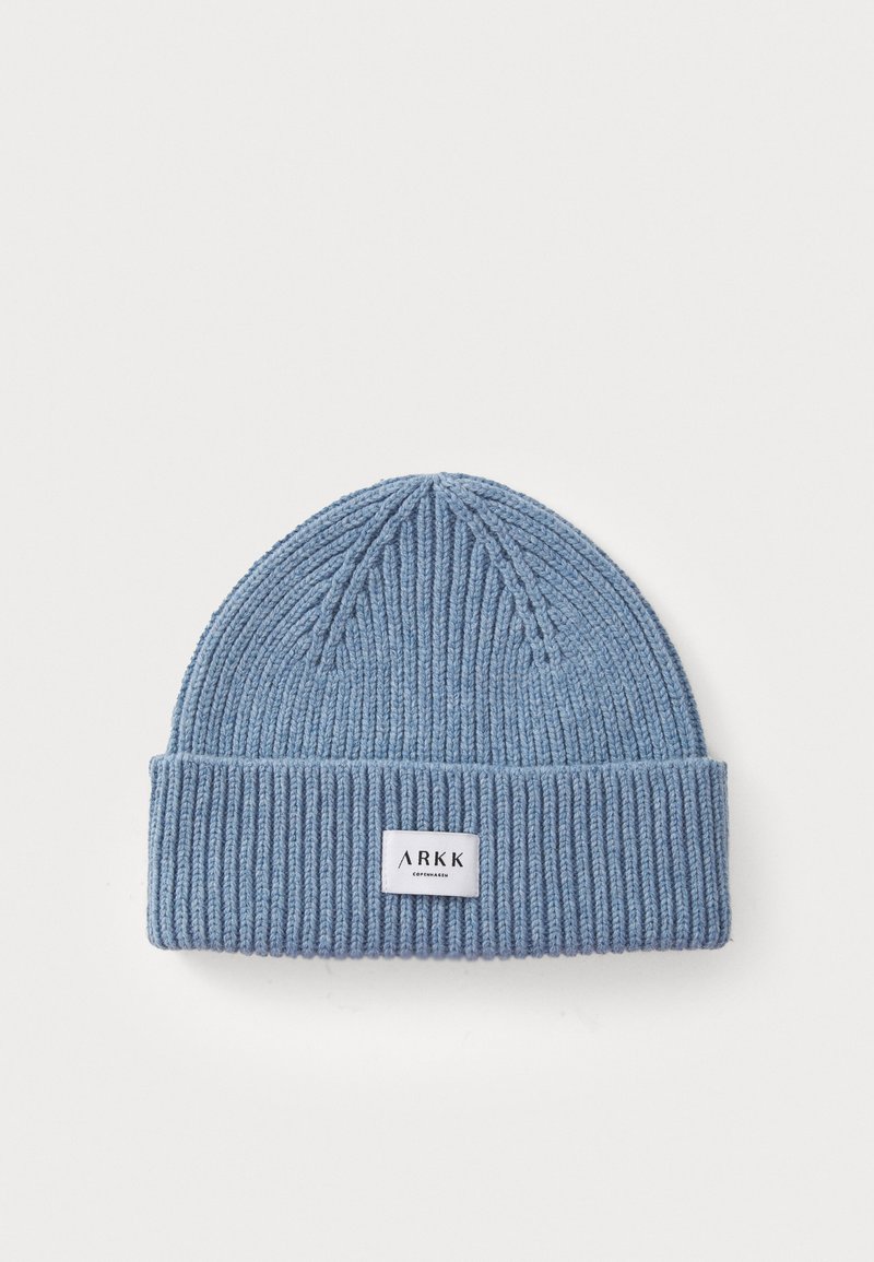 Bonnet tricoté bleu avec une texture côtelée, doté un revers et une étiquette rectangulaire portant "ARKK COPENHAGEN" en blanc.