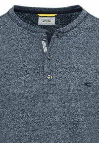 Mørkegrå tekstureret henley-skjorte med to-knaps placket, kontrasterende indvendig halsudskæring og lille logo-detalje på brystet.