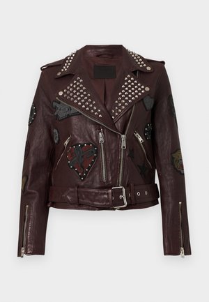 Geacă de motociclist din piele vișinie, cu nituri argintii, buzunare cu fermoar și diverse patch-uri brodate cu inimi și stele. Talie cu curea.