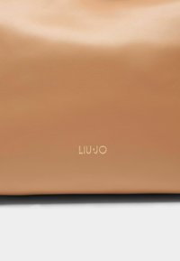 Borsa a mano in pelle color cuoio con una texture liscia, caratterizzata da un logo "LIU.JO" in rilievo dorato. Forma semplice e rettangolare.