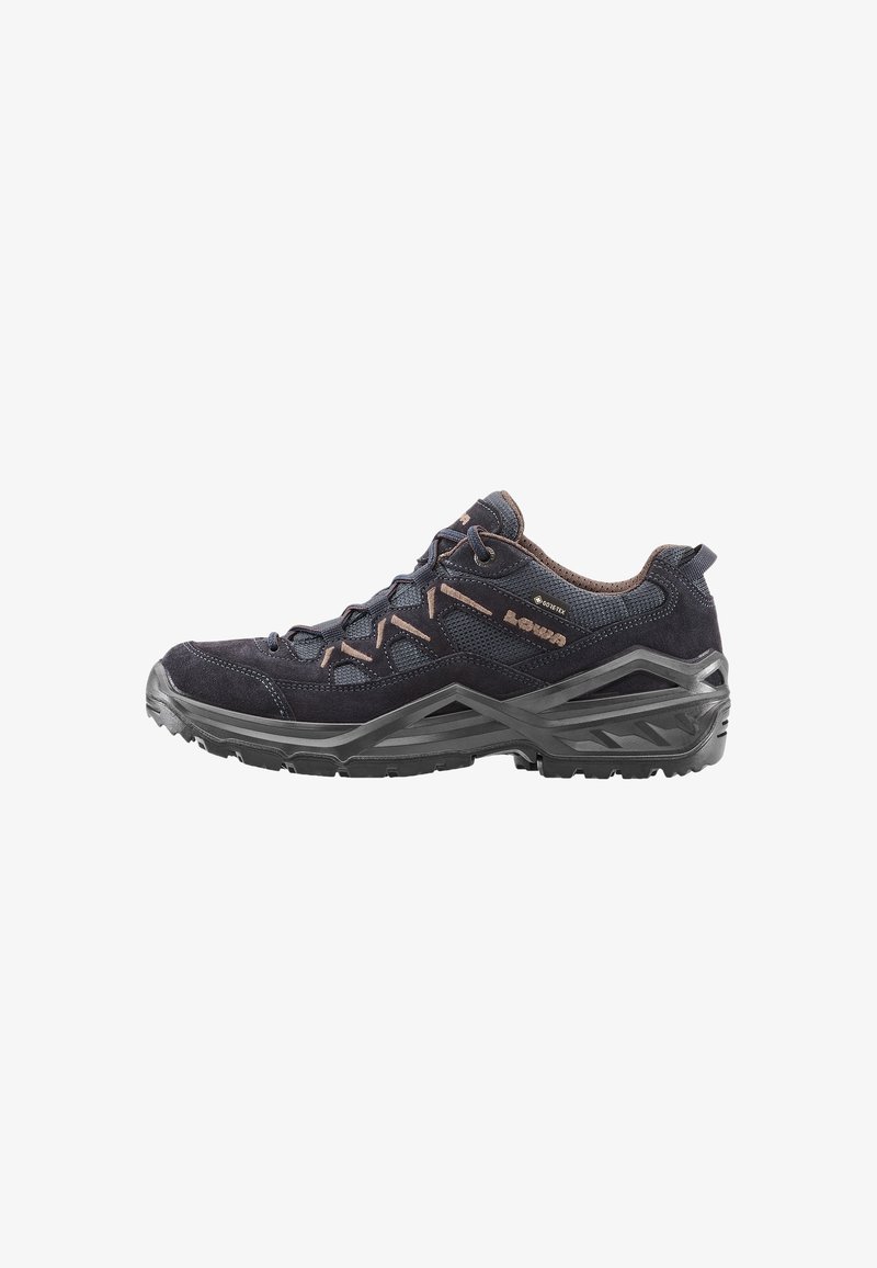 Zapato de senderismo bajo, en negro y marrón, con suela de goma gruesa, parte superior de malla y ante, con cordones en la parte delantera y etiqueta de impermeabilidad Gore-Tex en el lateral.