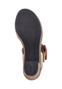 Semelle de sandale en caoutchouc avec une surface noire texturée, présentant un bord marron et un logo. Conçue pour la stabilité et l'adhérence.