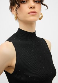 Černý žebrovaný top bez rukávů s vysokým límcem, zdobený malými flitry. Hladká textura, přiléhavý střih a minimalistický design.