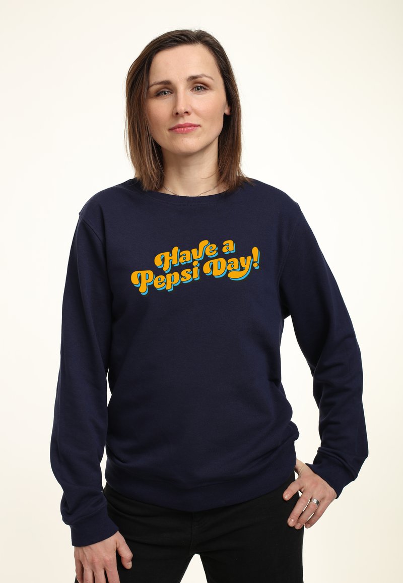 Felpa blu navy in misto cotone con maniche lunghe, caratterizzata da una grafica testuale audace in giallo e arancione: "Fai una giornata Pepsi!"