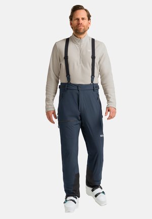 Skibroek in donkerblauw met zwarte accenten, verstelbare bretels, meerdere met rits gesloten zakken en een gladde, waterdichte textuur.