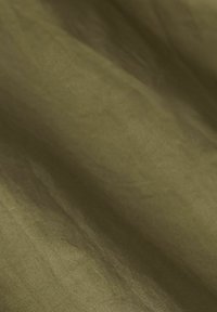 Olive green fabric with a soft, textured surface, displaying subtle variations in tone and a slightly wrinkled appearance.