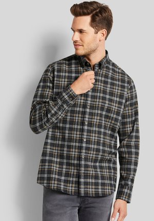 Button-up flannel shirt in black with white and beige plaid pattern. Features a collar, long sleeves, and button closures. Smooth texture.