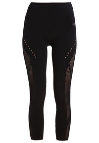 Czarne legginsy z wysokim stanem, z siateczkowymi wstawkami i wzorami w kropki po bokach. Wykonane z elastycznego, oddychającego materiału.