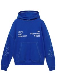 Blauwe capuchontrui met voorzak, witte tekst "JE ZULT ALLEEN DE ECHT GOEDE DINGEN HERINNEREN" en witte stikseldetails op de mouwen.