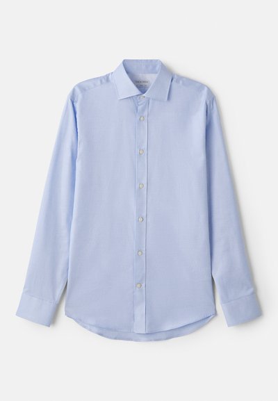 Lys blå langermet skjorte i vevd stoff, med knappelukking foran, spredt krage og avrundet nederkant. Enkel design med subtil tekstur.