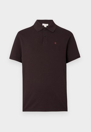 Black polo shirt made of cotton with a classic collar, two buttons, and a small red logo on the chest. Short sleeves, smooth texture.