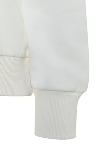 White sweatshirt sleeve featuring a ribbed cuff and soft texture, showcasing a snug fit and a smooth, plain fabric design.