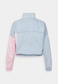 Zkrácená džínová bunda s světle modrým tělem a růžovými rukávy. Má stojáček a elastické manžety s jemnými švy.