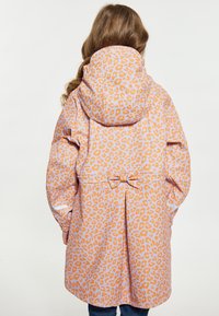 Vodonepropusni kaput svijetlo ružičaste boje s narandžastim leopard printom. Ima kapuljaču, skupljeni struk s mašnom i duge rukave.