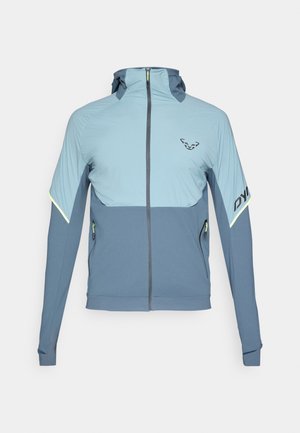 Chaqueta con capucha en telas azul claro y azul oscuro, con cierre de cremallera en la parte delantera, costuras a contraste y detalles reflectantes en las mangas y los bolsillos.