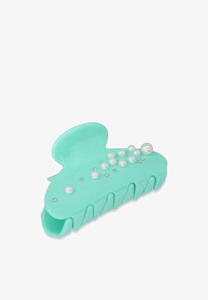 Een turquoise kunststof haarspeld met een gladde afwerking, versierd met parel- en rhinestoneaccenten, en een golvende randontwerp.