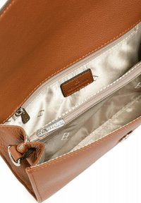 Interno di una borsa in pelle marrone con fodera in satin beige. Presenta una tasca con zip e un'etichetta, mettendo in risalto una texture liscia e un design pulito.