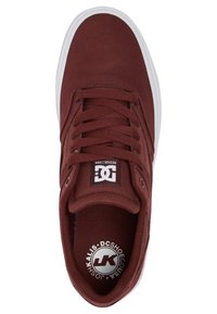 Bordeauxfarbene Canvas-Skate-Schuhe mit einer flachen weißen Gummisohle, runden Schnürsenkeln, einem Logo auf der Zunge und subtilen strukturierten Details.