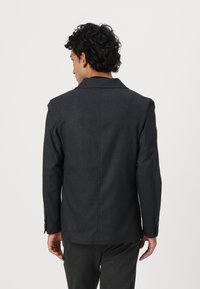 Donkergrijze blazer met een getailleerde pasvorm, een enkelvoudig knoopdesign, geknipte revers, sluiting met twee knopen en lange mouwen. Glad materiaal, minimale detaillering.