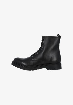 Bottine noire en cuir avec un laçage à l'avant, bout arrondi, semelle en caoutchouc robuste et une petite languette à l'arrière. Texture lisse avec des détails de design minimaux.