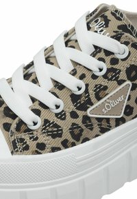 Sneaker in tela leopardata con lacci bianchi e suola in gomma. Presenta un accento metallico marchiato sul lato e una suola intermedia testurizzata.