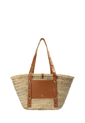 Bolso tote de paja tejida con largas correas de cuero marrón claro y bolsillo frontal de cuero adornado con remaches plateados y un pequeño emblema dorado.