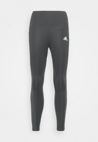 Vysoké černé legíny vyrobené z elastické tkaniny, s hladkým texturem a vyšitým bílým logem na levém boku.