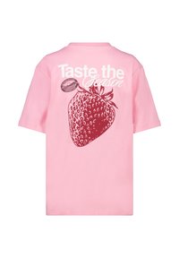 Pink cotton t-shirt featuring a large red strawberry graphic and the text "Taste the Season" in white, with short sleeves and a relaxed fit.