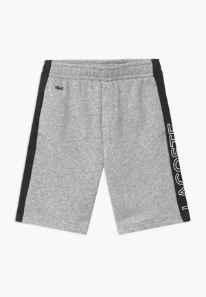 Shorts de sport gris avec panneaux latéraux noirs, texte blanc "LACOSTE" sur le panneau droit, taille élastique et petit logo crocodile vert sur le côté gauche.