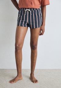 Marine gestreepte shorts met lichtroze lijnen, een elastische tailleband en een trekkoord. Het materiaal lijkt zacht en geschikt voor casual wear.
