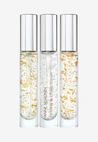 Three glass serum bottles with silver caps, containing liquid with gold flakes, labeled "Firming & Lifting Serum," varying in liquid color.