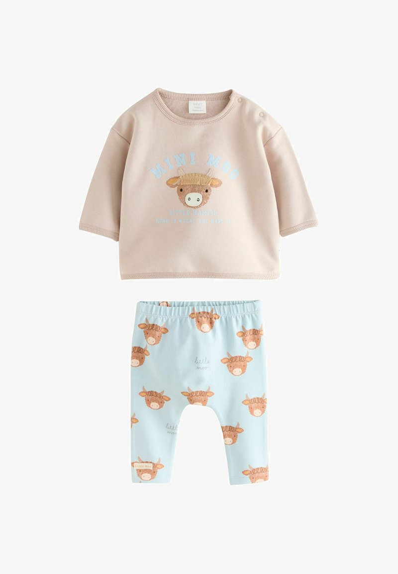 Sweat-shirt bébé marron clair avec visage de vache brodé et texte "MINI MOO", accompagné d'un pantalon bleu avec des visages de vache répétitifs.