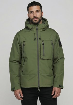Olive green insulated jacket with a hood, multiple zippered pockets, adjustable drawstrings, and black fabric accents. Smooth, water-resistant texture.