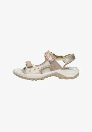 Beige en metallic open-teen verstelbare sandaal met dikke zool en gevoerde banden, geschikt voor buiten of casual gebruik.