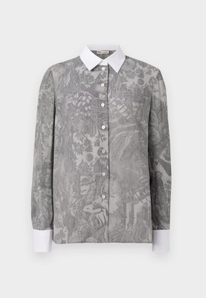 Camisa de manga larga en tejido gris con un intrincado patrón tonal, cuello blanco y cierre de botones. Presenta diseños botánicos y figurativos detallados.
