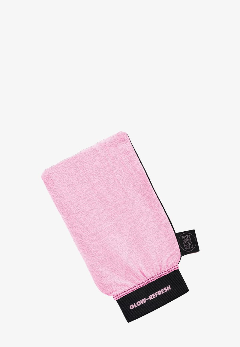 Roze, pluche exfoliërende handschoen met elastische manchet. Bevat de tekst "GLOW-REFRESH" en een klein zwart label met het logo van "THE FOX TAN". Rectangulaire vorm.